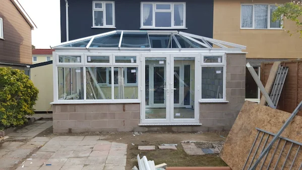 A block work extension into the back of a house ncluding the installation of a new White upvc Conservatory with French Doors